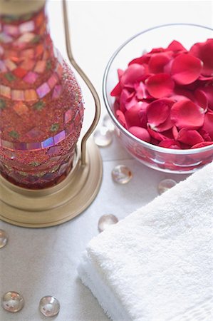 simsearch:630-01708292,k - Close-up of rose petals in a bowl with a stack of towels and a lantern Foto de stock - Sin royalties Premium, Código: 630-01708237