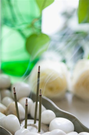 Close-up of burning incense sticks with white pebbles in a bowl Fotografie stock - Premium Royalty-Free, Codice: 630-01708245