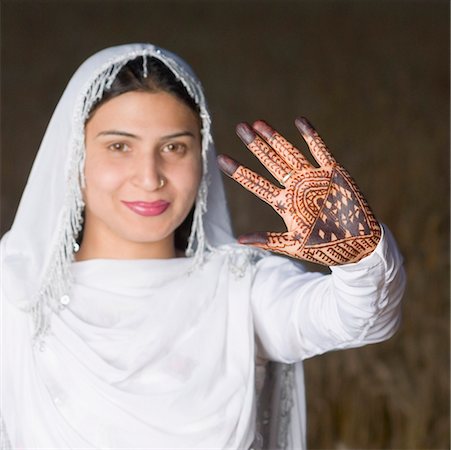 Portrait of a young woman showing mehndi on her palm Foto de stock - Sin royalties Premium, Código: 630-01708345