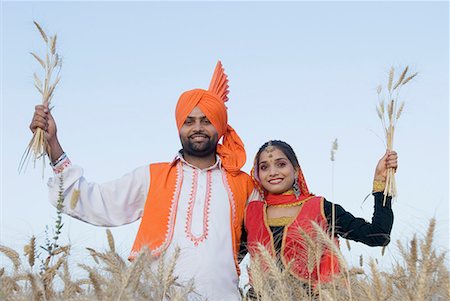 simsearch:630-01708339,k - Portrait of a young couple standing in a wheat field and holding crop Fotografie stock - Premium Royalty-Free, Codice: 630-01708341