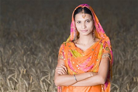 simsearch:630-01708339,k - Portrait of a young woman standing in a wheat field Fotografie stock - Premium Royalty-Free, Codice: 630-01708343