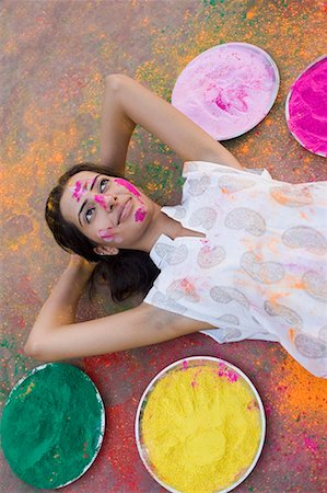 High angle view of a young woman lying down with plates of powder paint around her Stock Photo - Premium Royalty-Free, Code: 630-01708423