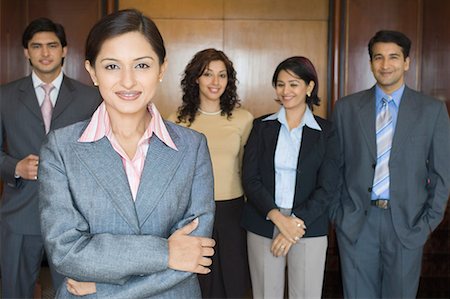 simsearch:630-06722386,k - Portrait of a businesswoman standing with her colleagues Stock Photo - Premium Royalty-Free, Code: 630-01708502