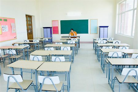 Teacher sitting in an empty classroom Stock Photo - Premium Royalty-Free, Code: 630-01708554