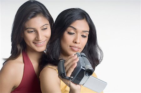 simsearch:630-01874443,k - Close-up of a young woman holding a home video camera and another young woman looking at it Stock Photo - Premium Royalty-Free, Code: 630-01708564