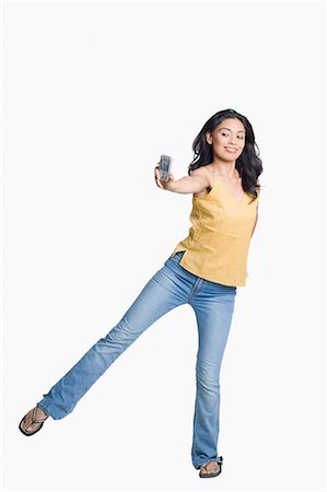 female in flip flops and jeans - Young woman standing on her one leg and taking a photograph of herself with a mobile phone Stock Photo - Premium Royalty-Free, Code: 630-01708574