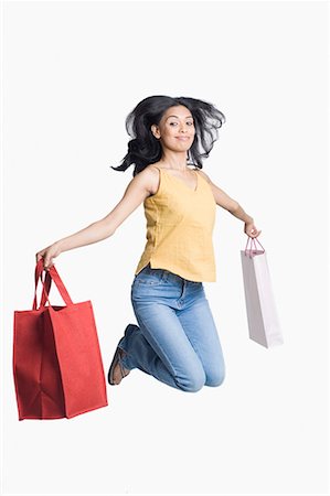 dîner (verbe) - Portrait of a young woman holding shopping bags and jumping Foto de stock - Sin royalties Premium, Código: 630-01708575