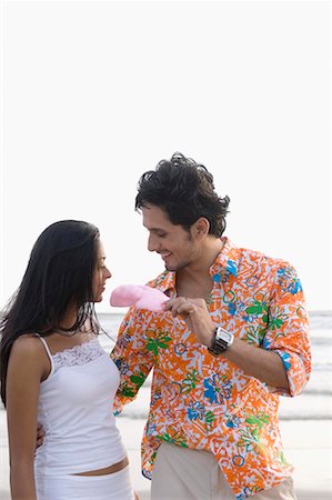 photo of a woman feeding her husband food - Young man offering a cotton candy to a young woman Stock Photo - Premium Royalty-Free, Code: 630-01708627