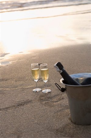 Champagne bottle in an ice bucket with two champagne flutes on the beach Stock Photo - Premium Royalty-Free, Code: 630-01708636