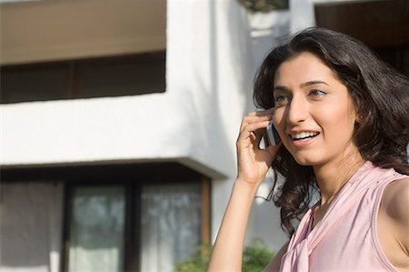 simsearch:630-01872828,k - Side profile of a young woman talking on a mobile phone and smiling Foto de stock - Royalty Free Premium, Número: 630-01708653