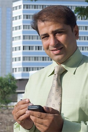 simsearch:630-01708706,k - Portrait d'un homme d'affaires à l'aide d'un téléphone mobile avec un stylet Photographie de stock - Premium Libres de Droits, Code: 630-01708695