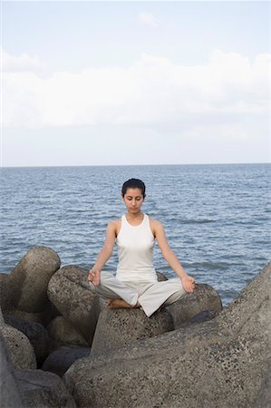 Young woman doing yoga on a rock Stock Photo - Premium Royalty-Free, Code: 630-01708717