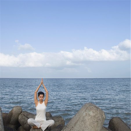 Young woman doing yoga on a rock Stock Photo - Premium Royalty-Free, Code: 630-01708721