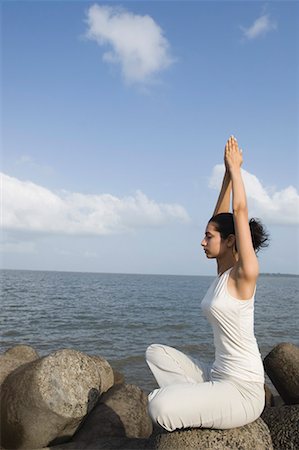 Side profile of a young woman doing yoga on a rock Foto de stock - Sin royalties Premium, Código: 630-01708735