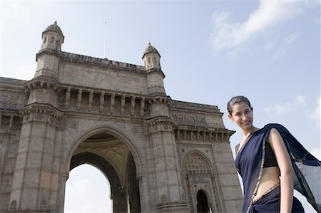 Portrait d'une jeune femme debout devant un monument, Gateway Of India, Mumbai, Maharashtra, Inde Photographie de stock - Premium Libres de Droits, Code: 630-01708757