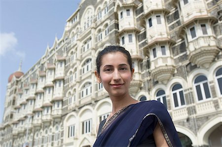 simsearch:630-01872968,k - Porträt einer jungen Frau lächelnd mit einem Hotel im Hintergrund, Taj Mahal Palace & Tower, Colaba, Indien Stockbilder - Premium RF Lizenzfrei, Bildnummer: 630-01708759