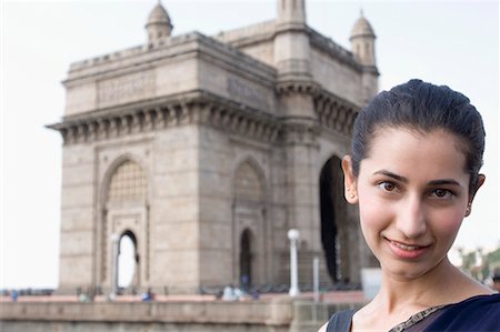 Portrait d'une jeune femme souriante avec un monument à l'arrière-plan, Inde Photographie de stock - Premium Libres de Droits, Code: 630-01708750