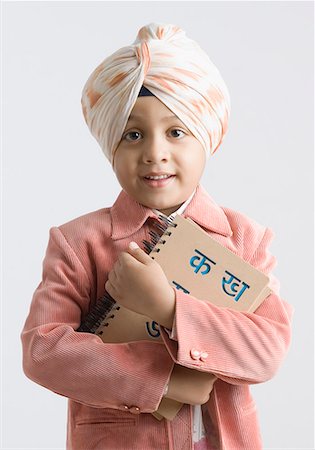 sikhism traditional clothing - Portrait of a boy hugging a spiral notebook and smiling Stock Photo - Premium Royalty-Free, Code: 630-01708785