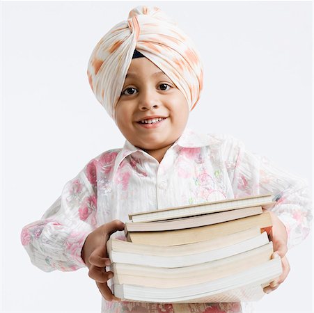 sikh boy alone images - Portrait of a boy holding a stack of books and smiling Stock Photo - Premium Royalty-Free, Code: 630-01708787