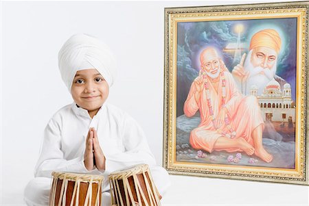 Portrait of a boy sitting in front of bongo and praying Stock Photo - Premium Royalty-Free, Code: 630-01708790
