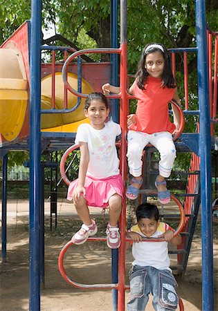 smirk girl - Portrait of a boy playing with two girls on the jungle gym Stock Photo - Premium Royalty-Free, Code: 630-01709083