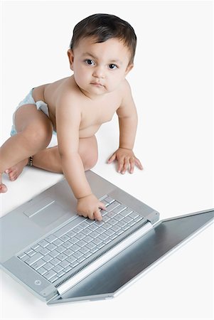 Portrait d'une petite fille jouant avec un ordinateur portable Photographie de stock - Premium Libres de Droits, Code: 630-01709100