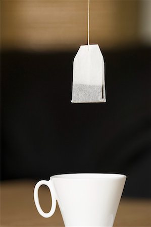 saquinho de chá - Teabag hanging over a tea cup Foto de stock - Royalty Free Premium, Número: 630-01709178