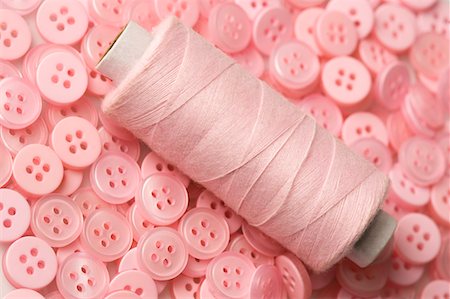 sewing still life - Close-up of a spool of pink thread with pink buttons Stock Photo - Premium Royalty-Free, Code: 630-01709630