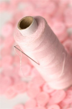 sewing top view - Close-up of a needle with a spool of pink thread and pink buttons Stock Photo - Premium Royalty-Free, Code: 630-01709631