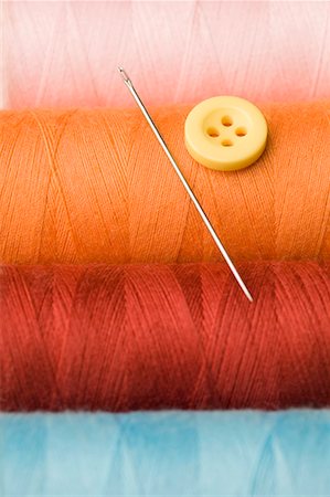 simsearch:400-06392816,k - Close-up of a button and a needle with spools of thread Foto de stock - Royalty Free Premium, Número: 630-01709644