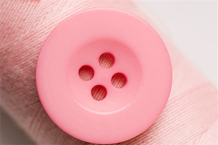 fashion holes - Close-up of a pink button with a spool of pink thread Stock Photo - Premium Royalty-Free, Code: 630-01709667