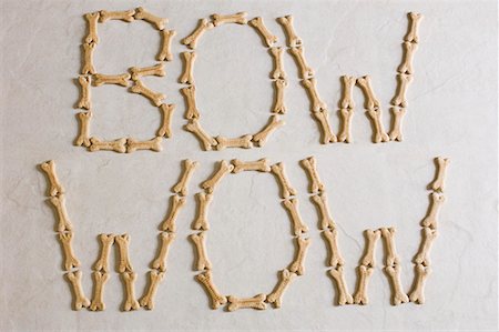 Gros plan des textes BOW WOW faite avec des biscuits pour chiens sur une surface blanche Photographie de stock - Premium Libres de Droits, Code: 630-01709706