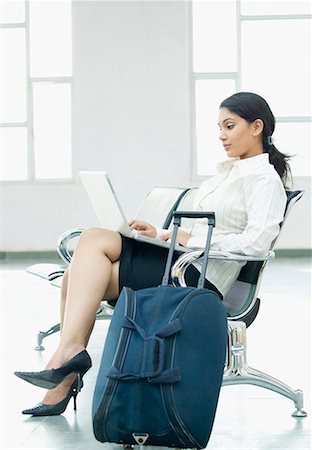 Profil de côté d'une femme d'affaires assis et à l'aide d'un ordinateur portable Photographie de stock - Premium Libres de Droits, Code: 630-01709896