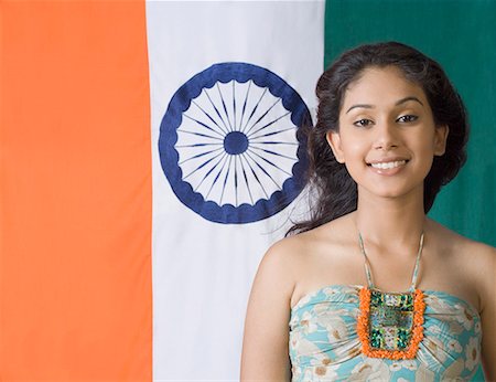Portrait of a young woman standing in front of an Indian flag Stock Photo - Premium Royalty-Free, Code: 630-01709916