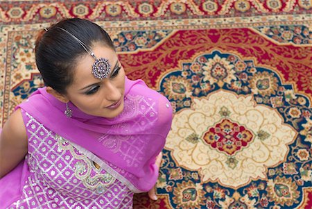 High angle view of a mid adult woman sitting on a carpet in salwar kameez Stock Photo - Premium Royalty-Free, Code: 630-01709999