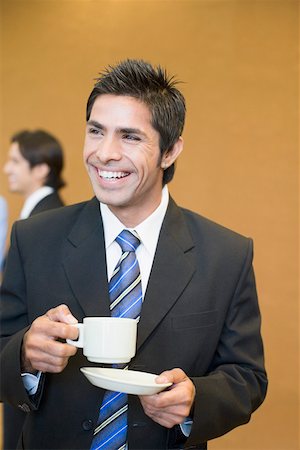 simsearch:630-01872567,k - Gros plan d'un homme tenant une tasse de thé avec une soucoupe et souriant Photographie de stock - Premium Libres de Droits, Code: 630-01874027