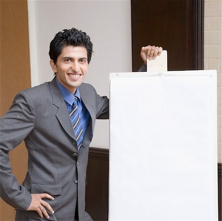 simsearch:630-01874091,k - Portrait of a businessman standing near a whiteboard and smiling Fotografie stock - Premium Royalty-Free, Codice: 630-01874147