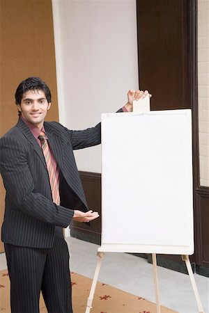 Portrait of a businessman giving presentation near a whiteboard Stock Photo - Premium Royalty-Free, Code: 630-01874150