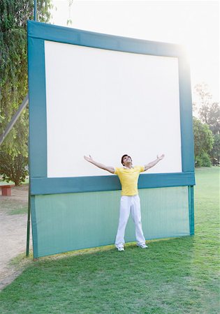 Young man standing with his arms outstretched in front of a whiteboard Foto de stock - Sin royalties Premium, Código: 630-01874174