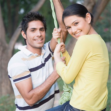 simsearch:630-01490862,k - Portrait of a young couple swinging on a tire swing and smiling Stock Photo - Premium Royalty-Free, Code: 630-01874209