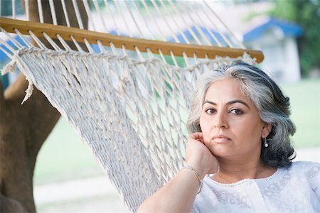 Portrait of a mature woman reclining in a hammock and thinking Stock Photo - Premium Royalty-Free, Code: 630-01874232