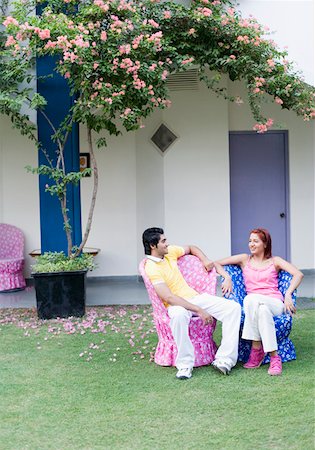 Young couple sitting in a lawn and smiling Stock Photo - Premium Royalty-Free, Code: 630-01874246