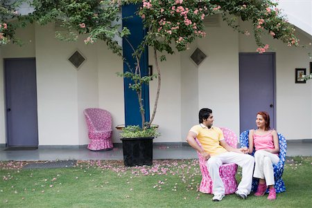 Young couple sitting in a lawn and smiling Stock Photo - Premium Royalty-Free, Code: 630-01874247