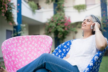 simsearch:630-01874237,k - Mature woman sitting on a chair and talking on a mobile phone Stock Photo - Premium Royalty-Free, Code: 630-01874257