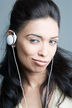 simsearch:630-01876536,k - Portrait of a young woman listening to headphones and smirking Stock Photo - Premium Royalty-Free, Code: 630-01874403