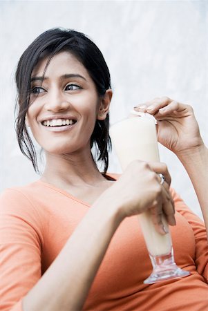 simsearch:630-01128103,k - Close-up of a young woman holding a glass of milkshake and smiling Stock Photo - Premium Royalty-Free, Code: 630-01874492