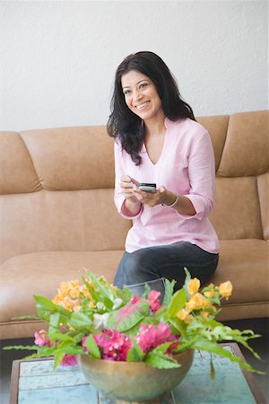 simsearch:630-01130881,k - Young woman holding a mobile phone and smiling Foto de stock - Sin royalties Premium, Código: 630-01874557