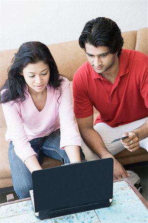 High angle view of a young couple shopping online with a credit card Stock Photo - Premium Royalty-Free, Code: 630-01874584