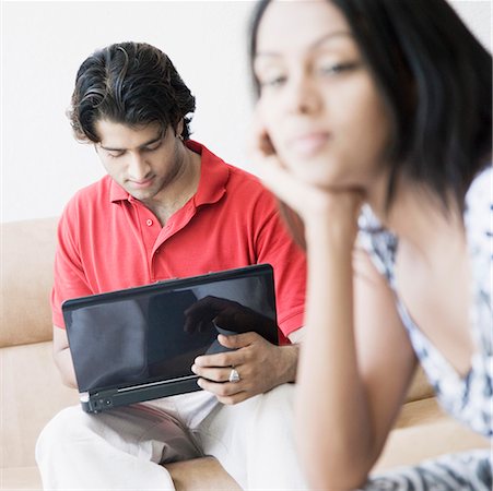 simsearch:630-01874614,k - Close-up of a young woman thinking with a young man using a laptop beside her Stock Photo - Premium Royalty-Free, Code: 630-01874612