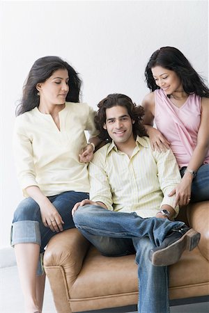 friends black background - Young man sitting between two young women Stock Photo - Premium Royalty-Free, Code: 630-01874701